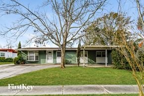 Jacksonville house for rent - a green house with a lawn and a tree