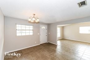Jacksonville house for rent - the living room and dining room with a white door and tile floor
