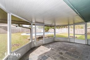 Jacksonville house for rent - a screened in porch with a view of a yard and a pool