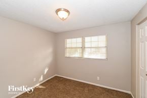 Jacksonville house for rent - a bedroom with a window and a carpeted floor