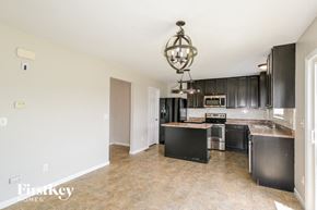 O'fallon house for rent - a large kitchen with black cabinets and a counter top