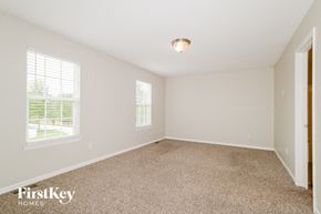 O'fallon house for rent - a bedroom with a carpeted floor and two windows