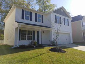 Fuquay Varina house for rent - A white house with a grey roof and a black tree in front.