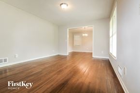 Forest Park house for rent - an empty living room with wood flooring and white walls