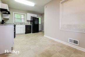 Forest Park house for rent - a kitchen with white cabinets and a black refrigerator