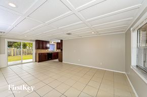 Ocoee house for rent - an empty living room and kitchen with a sliding glass door