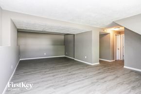 Indianapolis house for rent - A spacious room with wooden flooring and a white ceiling.