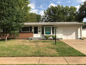 Florissant house for rent - a white house with a lawn and a white garage door