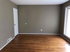 Florissant house for rent - an empty room with wooden floors and gray walls