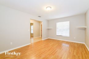 Deltona house for rent - the living room and dining room with wood flooring and white walls