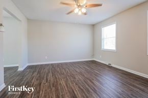 Kansas City house for rent - the spacious living room with hardwood flooring and a ceiling fan
