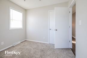 Kansas City house for rent - a bedroom with white walls and carpet and a door to a closet