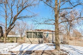 Kansas City house for rent - a small house with a yard and trees in the snow