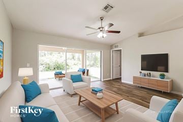 Lehigh Acres house for rent - A living room with a wooden coffee table and a flat screen TV on a cabinet.