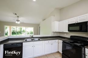 Lehigh Acres house for rent - A kitchen with a black counter top and white cabinets.