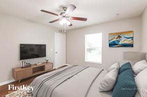 Lehigh Acres house for rent - A bedroom with a bed, a television, and a painting on the wall.