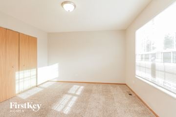 Joliet house for rent - a spacious living room with a large window and carpet