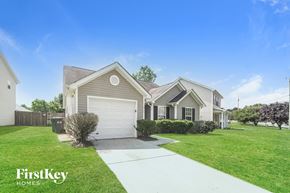 Charlotte house for rent - a beige house with a white garage door and a lawn