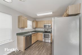 Charlotte house for rent - a kitchen with wooden cabinets and stainless steel appliances