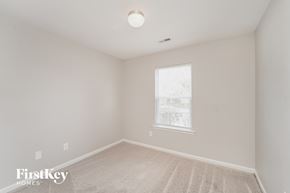 Charlotte house for rent - a bedroom with white walls and white carpet and a window