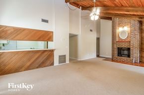 Winter Springs house for rent - an empty living room with a brick fireplace and a wood floor
