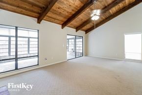 Winter Springs house for rent - an empty living room with exposed wood ceilings and a large window