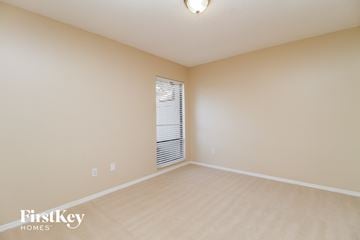 Winter Springs house for rent - a spacious living room with beige carpet and a window