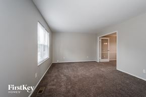 Fenton house for rent - a bedroom with a carpeted floor and a large window