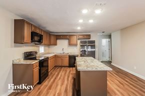 Tampa house for rent - a kitchen with wooden cabinets and stainless steel appliances and marble counter tops