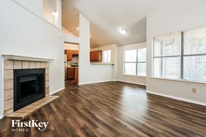 Lewisville house for rent - A spacious living room with wood flooring and a fireplace.