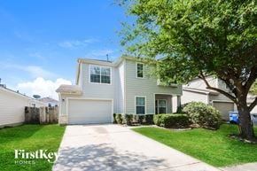Houston house for rent - A house with a driveway and a tree in front of it.