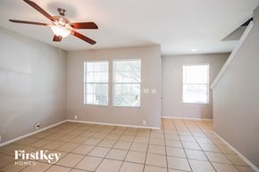 Houston house for rent - A spacious room with a ceiling fan and tiled flooring.