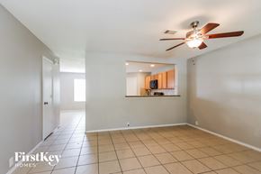 Houston house for rent - A spacious room with a ceiling fan and tiled flooring.