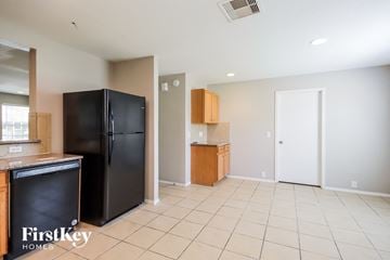 Houston house for rent - A kitchen with a black fridge and wooden cabinets.