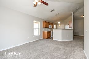 Auburndale house for rent - an empty living room with a kitchen and a ceiling fan