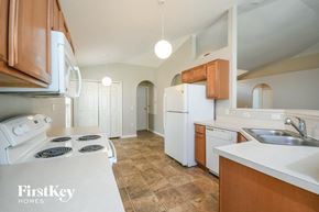 Auburndale house for rent - a kitchen with white appliances and wooden cabinets