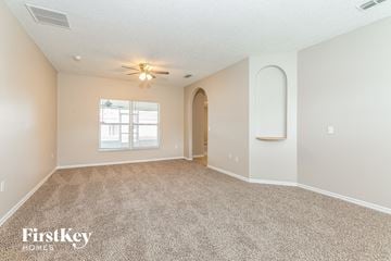Kissimmee house for rent - a spacious living room with carpet and a window