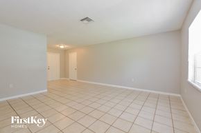 Mount Dora house for rent - an empty living room with tiled flooring and a door to a hallway