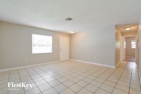 Mount Dora house for rent - an empty living room with tiled flooring and a white door