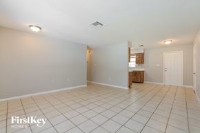 Mount Dora house for rent - an empty living room with tile flooring and a kitchen