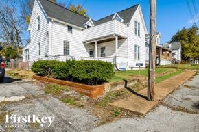 Saint Louis house for rent - the front of a white house with a yard with a planter