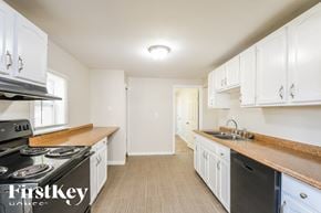 Saint Louis house for rent - a kitchen with white cabinets and a stove and a sink