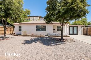 Tempe house for rent - A white house with a gravel driveway and trees in front.