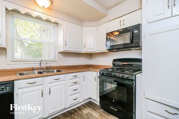 Florissant house for rent - A kitchen with a black oven and white cabinets.