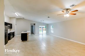 Port St. Lucie house for rent - A spacious living room with a kitchen area in the background.