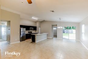 Port St. Lucie house for rent - A spacious kitchen and living room with a refrigerator, stove, and oven.