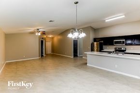Port St. Lucie house for rent - A spacious kitchen and living room with a chandelier and a dining table.