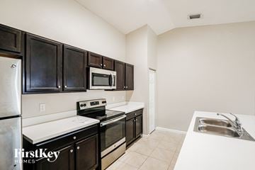 Port St. Lucie house for rent - A kitchen with black cabinets and stainless steel appliances.