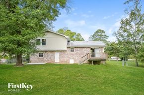 Conyers house for rent - a stone house with a deck and a grass yard