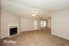 Jonesboro house for rent - a living room with a fireplace and a ceiling fan